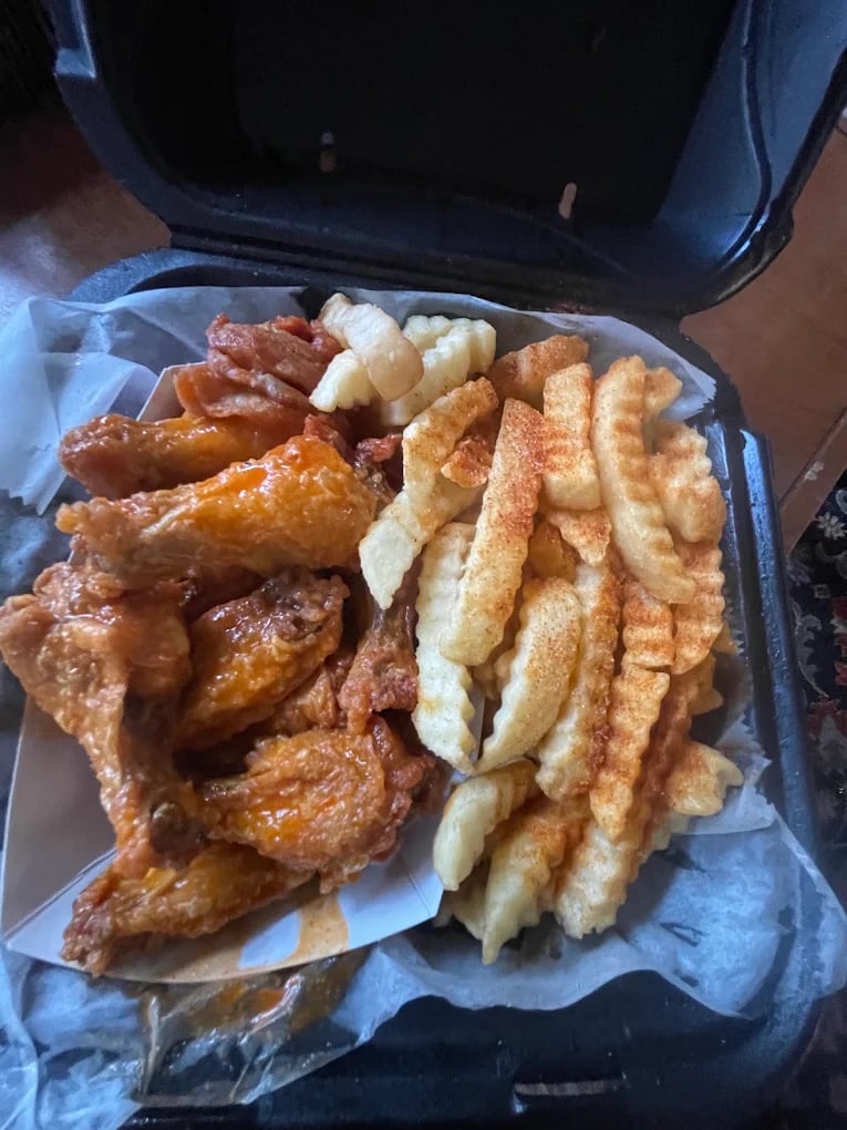 A restaurant's real takeout photo of wings and fries, before and after MenuPhotoLab (before)